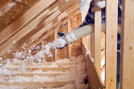 blown in insulation being blown into an attic